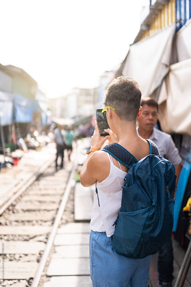 Tourist taking photos in Maeklong market.