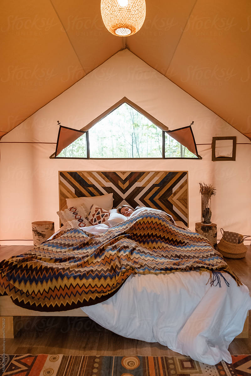 Woman sleeping on bed in weekend tent