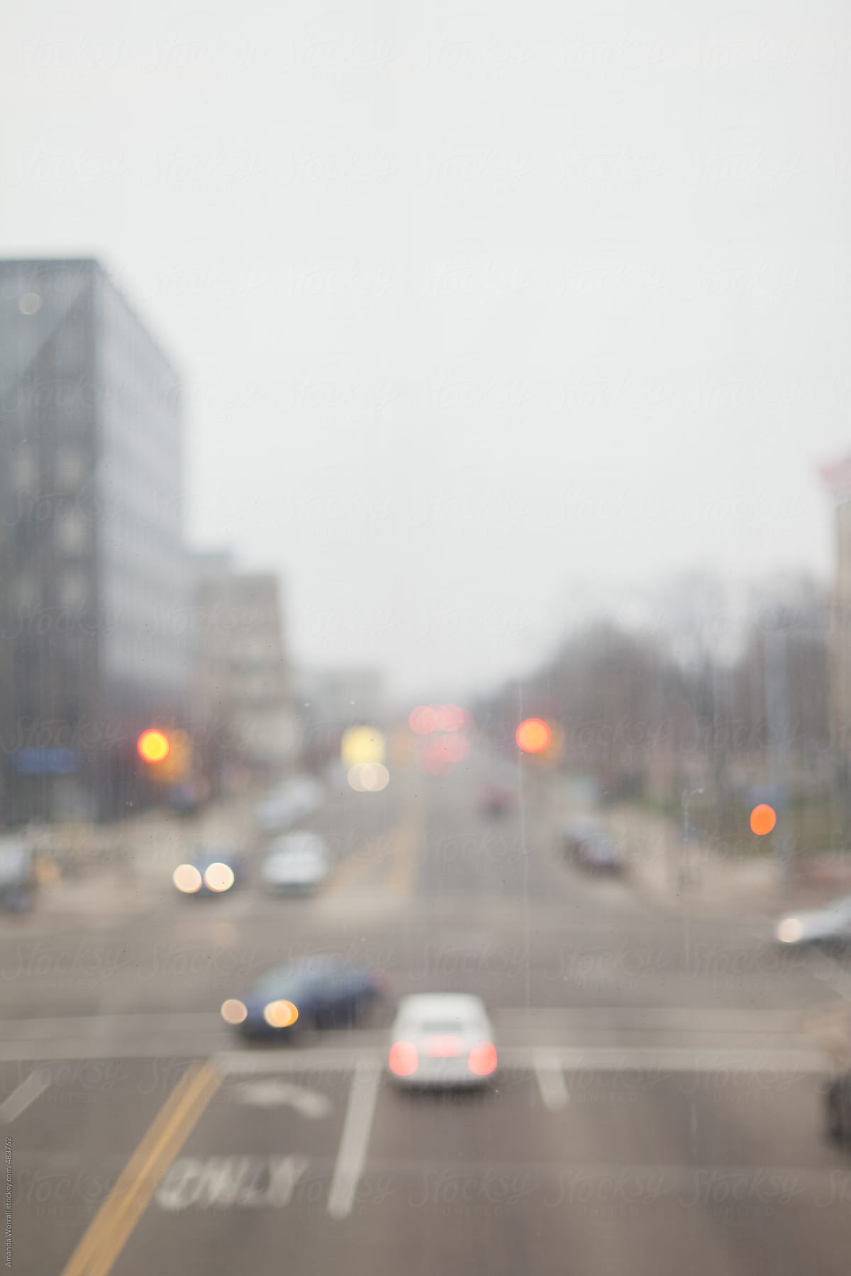 Out of focus view of city intersection through a dirty window