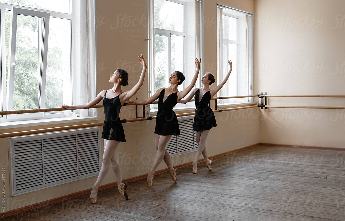 Young ballerinas tiptoeing with raised arms