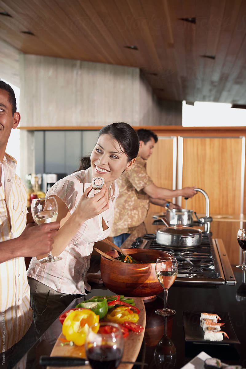 Group of multi-ethnic friends prepping for dinner party in the kitchen