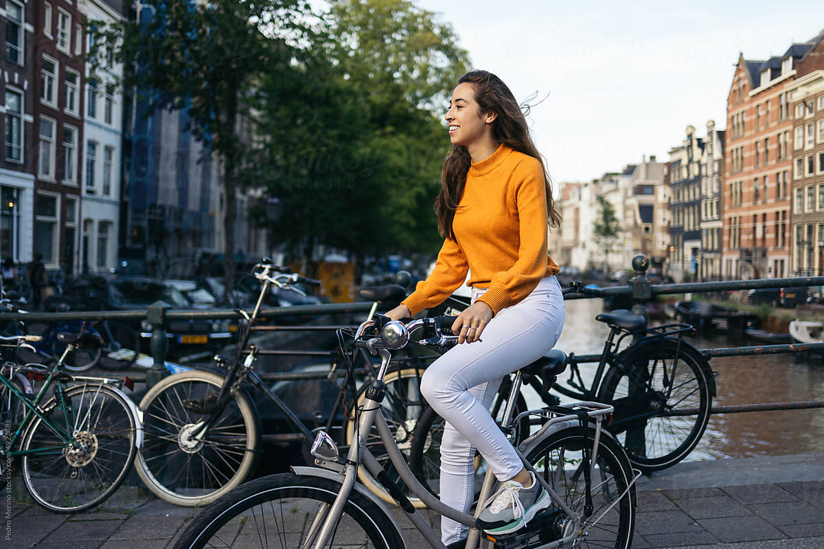 Happy young woman taking a bike ride in amsterdam