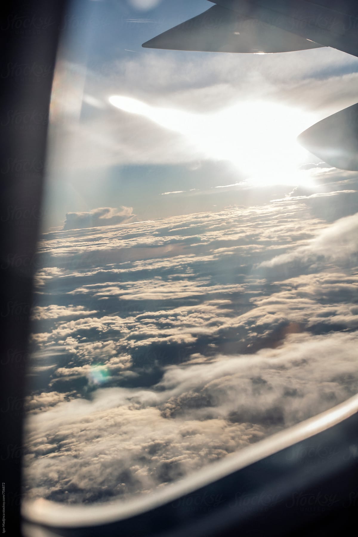 view through the airplane window,sun ray a beautiful white clouds after a storm