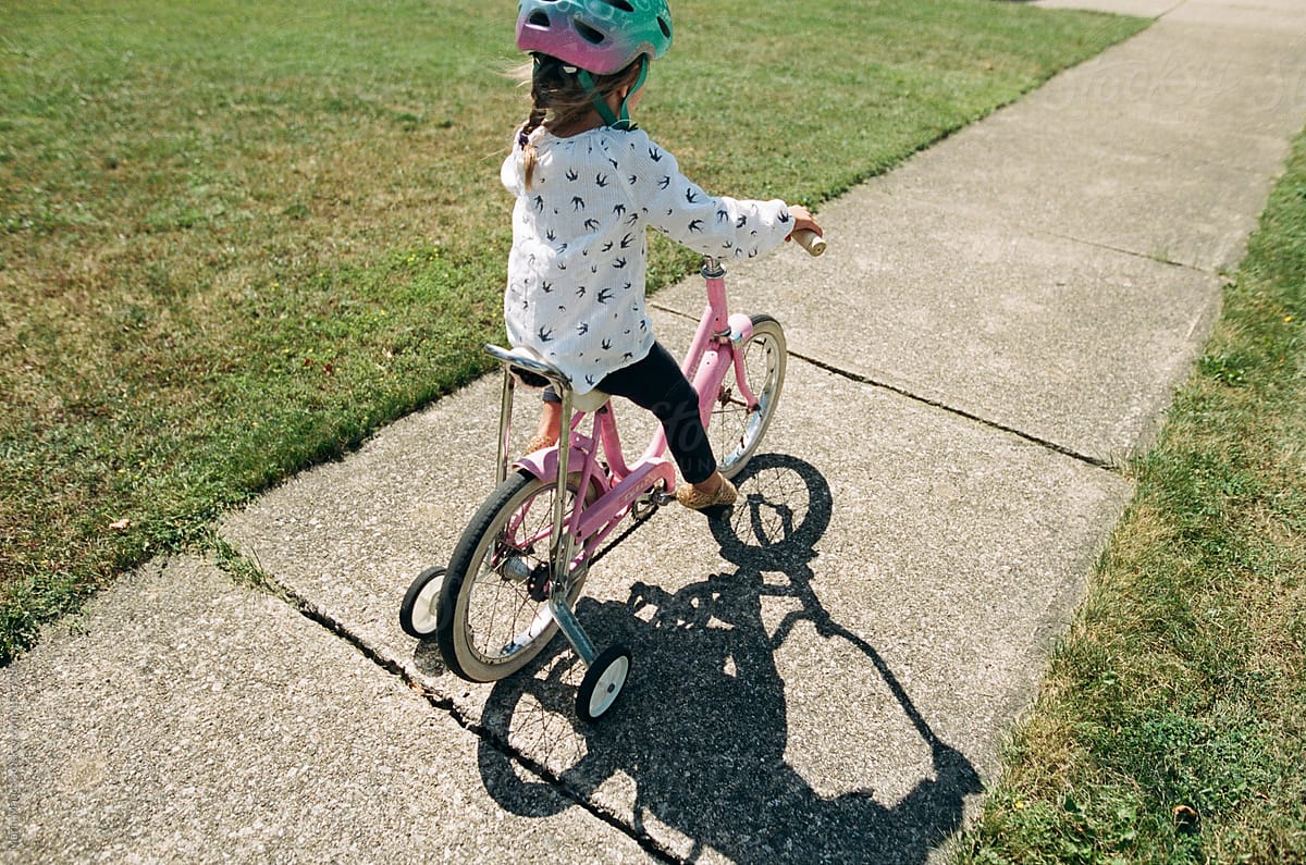 Girl on bike with training wheels
