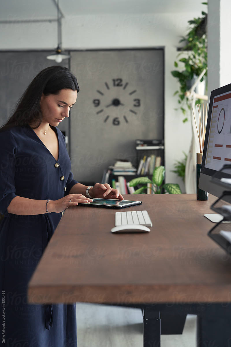 Elegant female worker using tablet at desktop