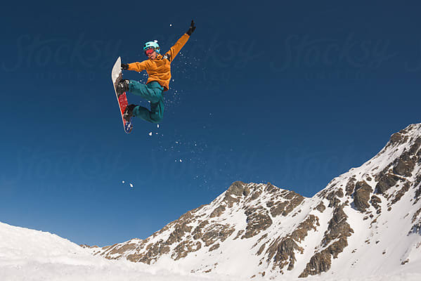 Male Snowboarder Performing Extreme Mid-air Trick