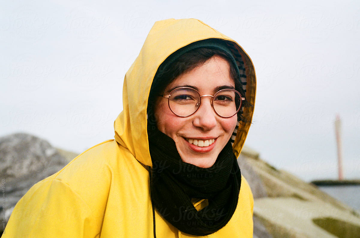 Portrait of a positive smiley woman wearing a yellow raincoat
