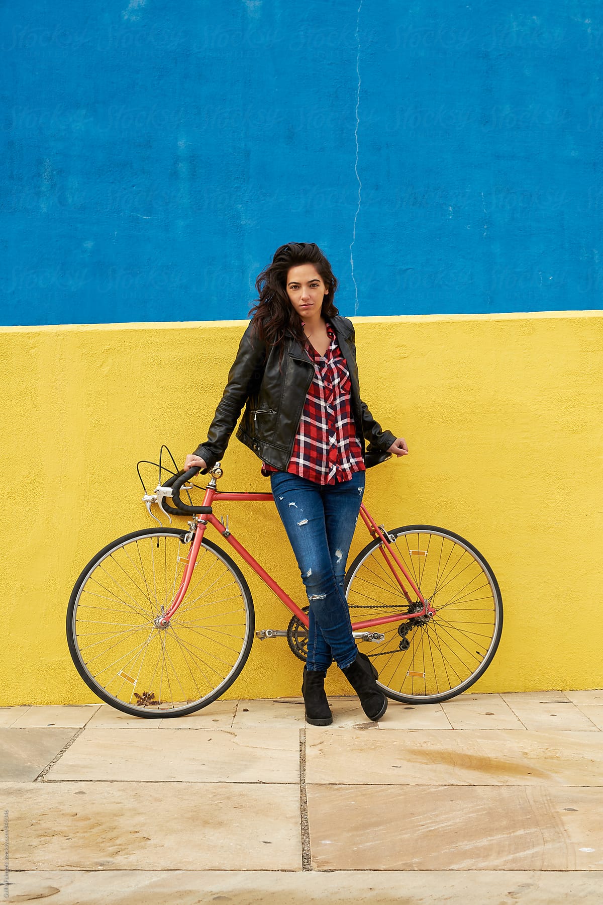Female with bike resting near colorful wall