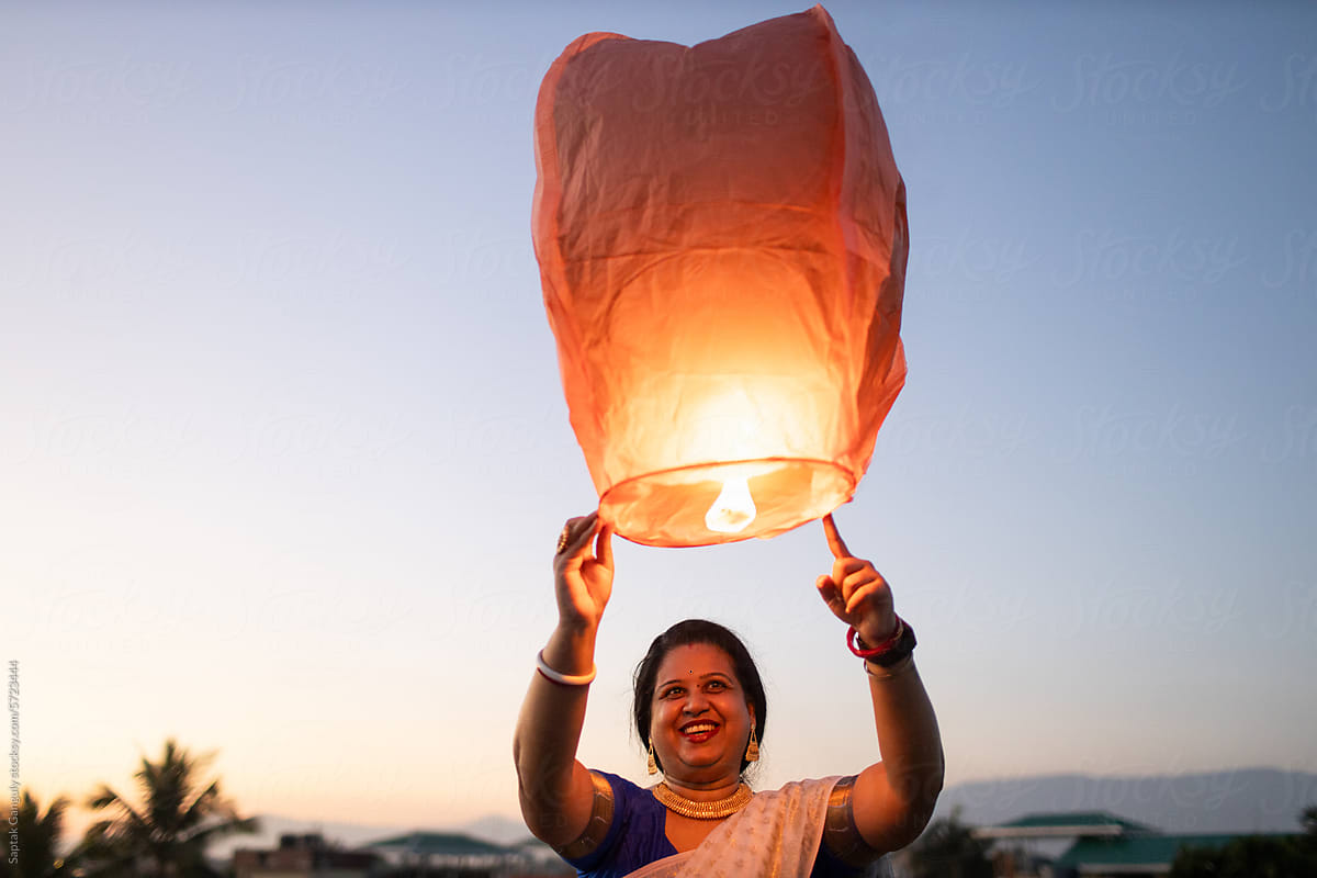 Woman releasing sky lantern at twilight