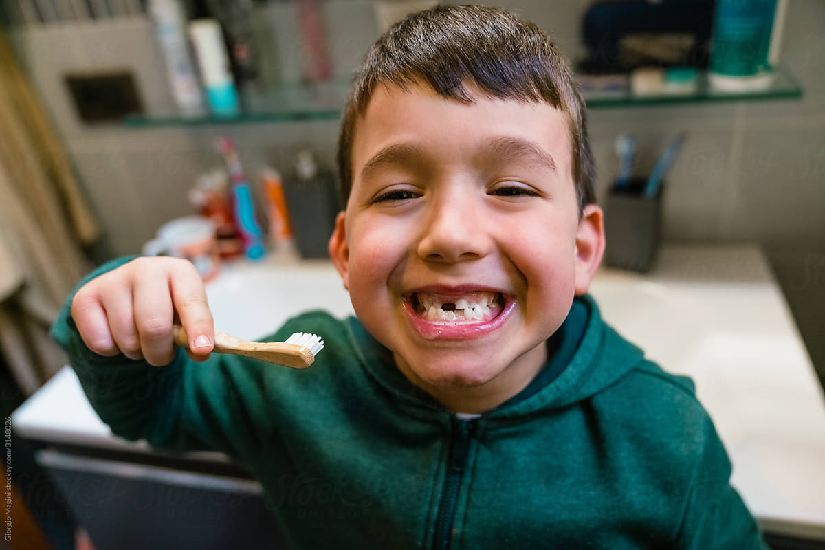 Happy boy with toothbrush showing teeth
