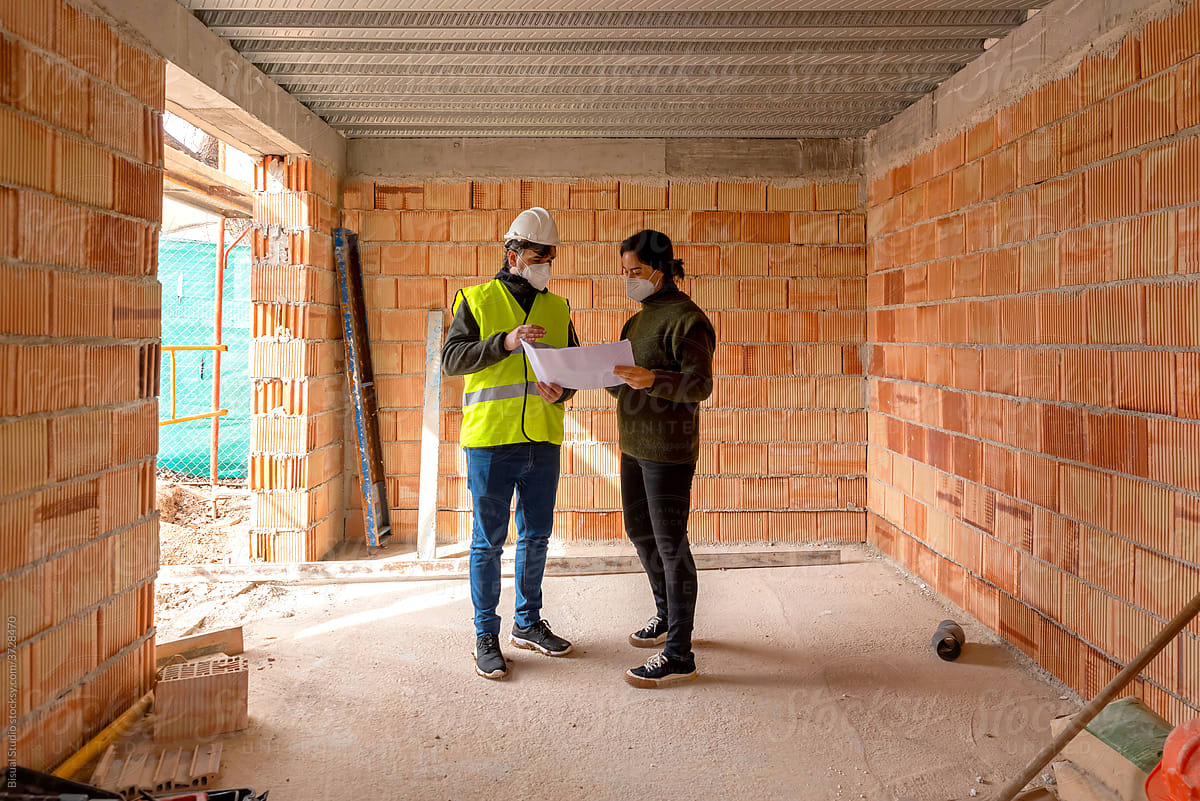 Builder and client discussing draft of new house