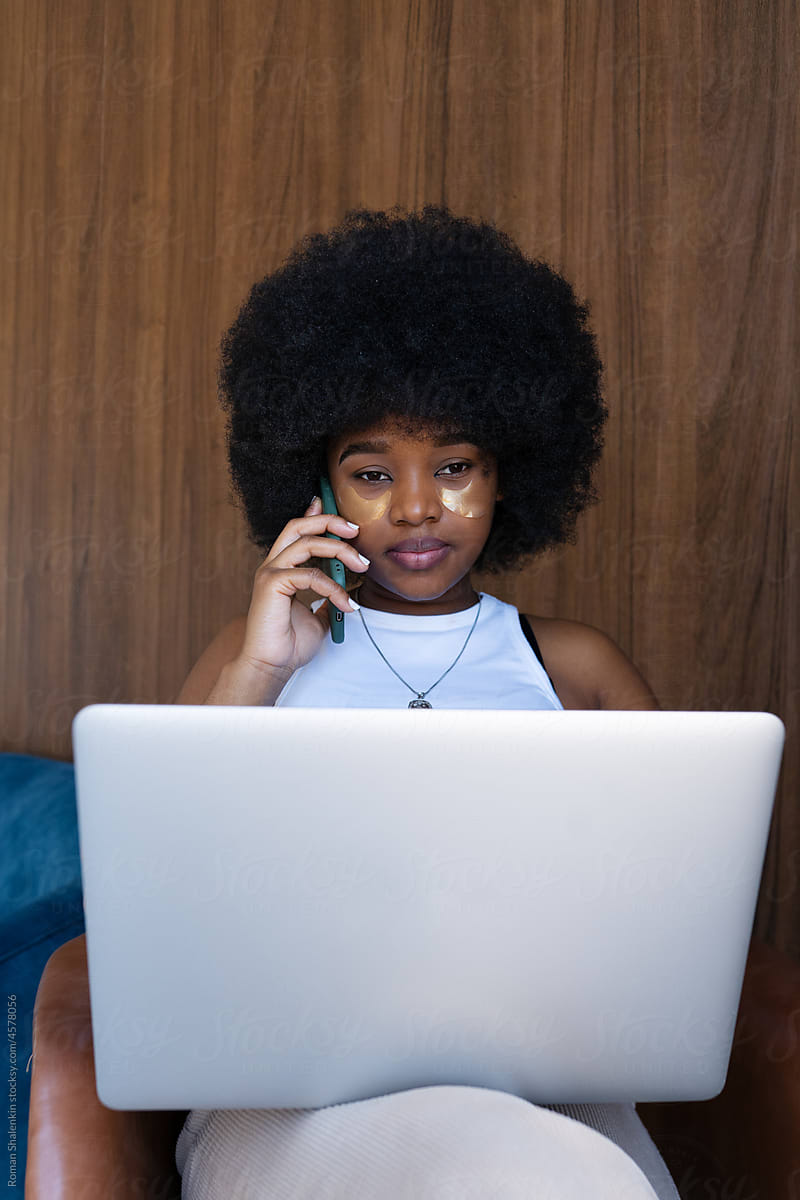 Female freelancer having phone conversation in armchair