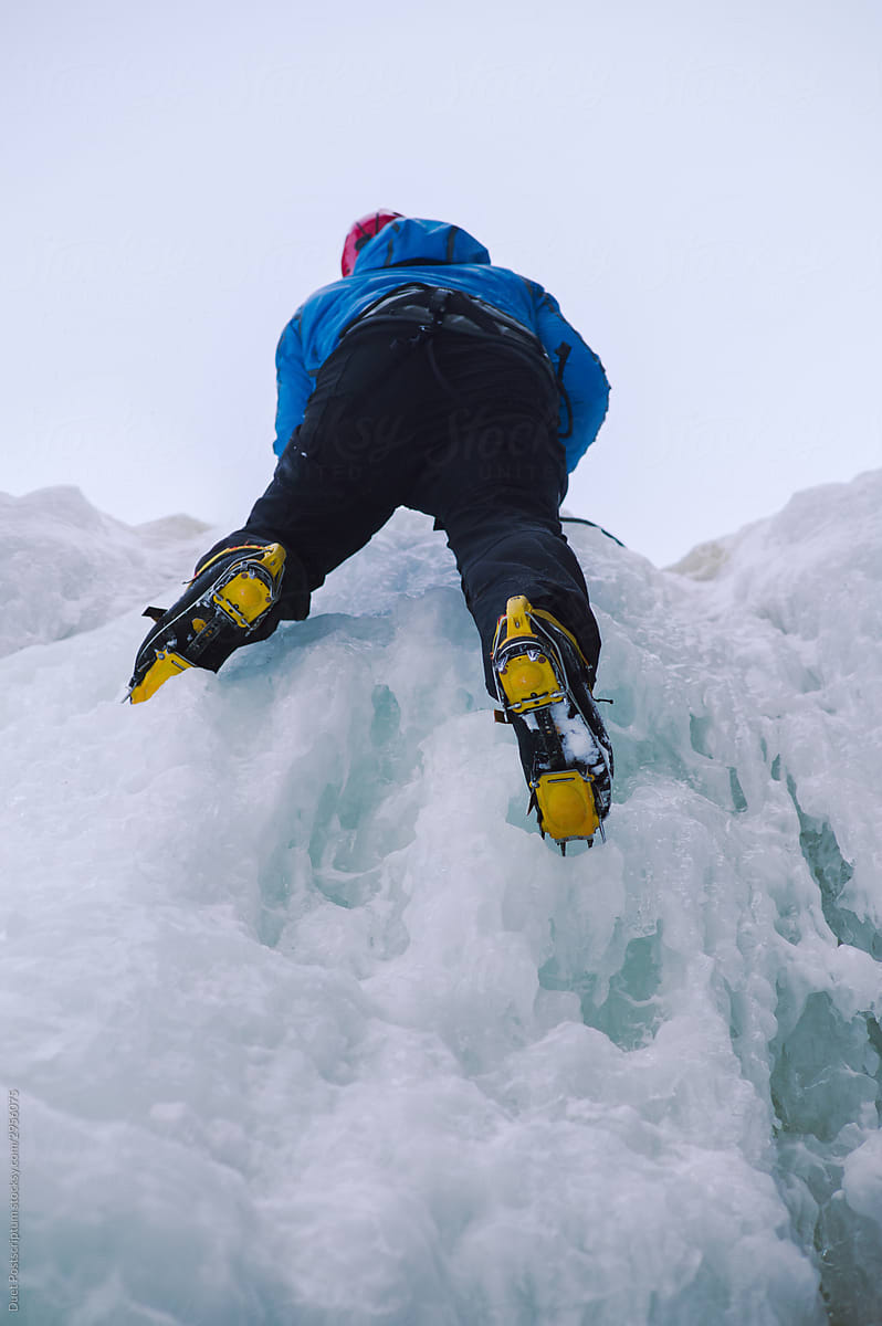 Climber climbs on a frozen waterfall