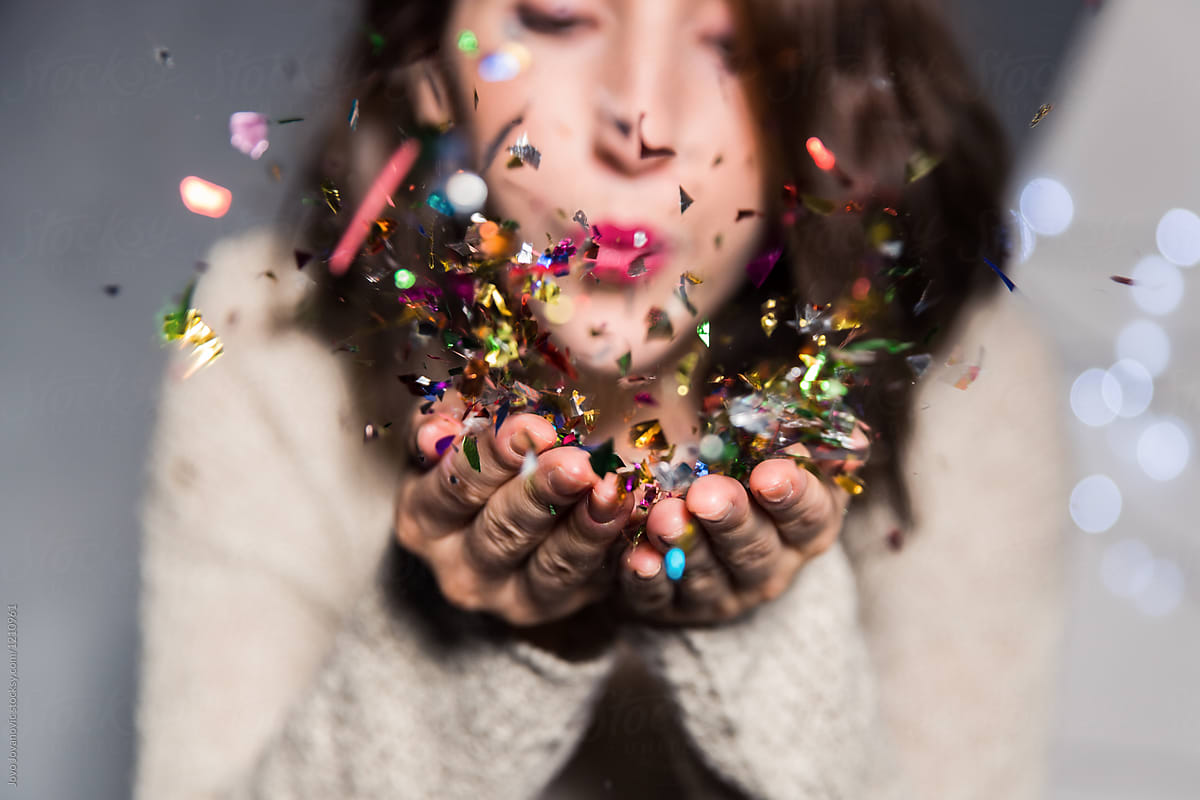 «Woman Blowing Confetti Off Her Hands» del colaborador de Stocksy «Jovo ...