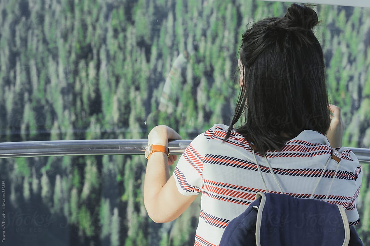 Young woman overlooking forest from above