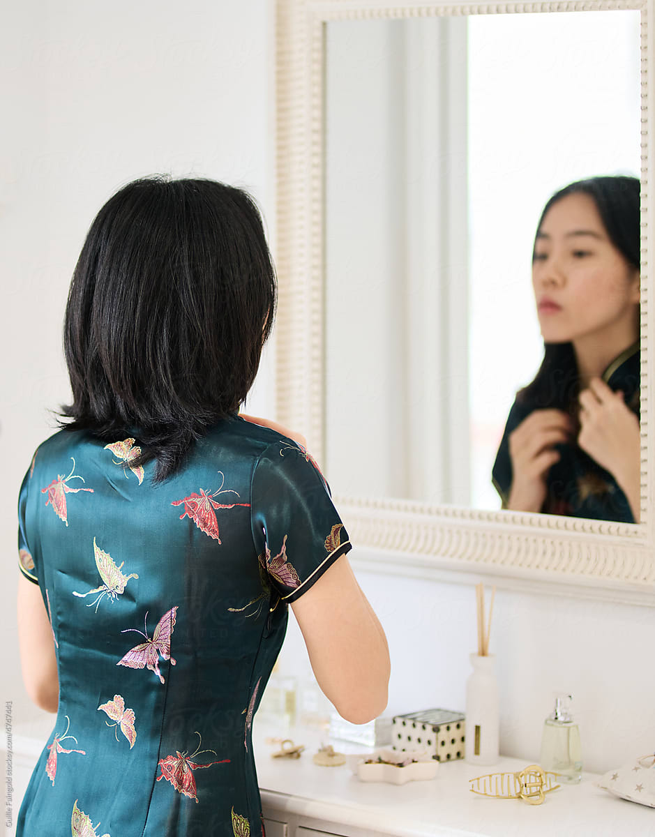 Chinese woman looking in mirror