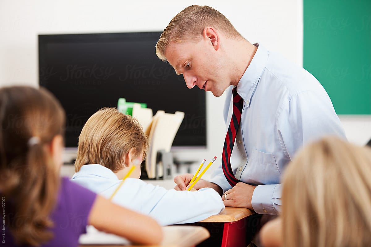 Classroom: Male Teacher Assisting Schooboy with Assignment