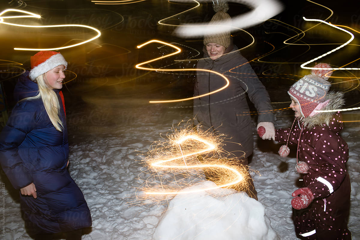 Woman and children light sparklers