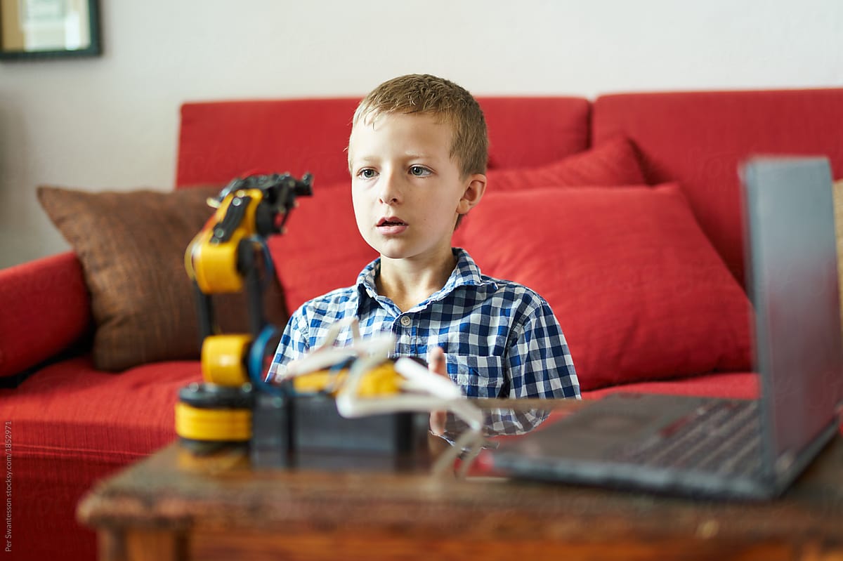 Concentrated boy learning how to program a robot