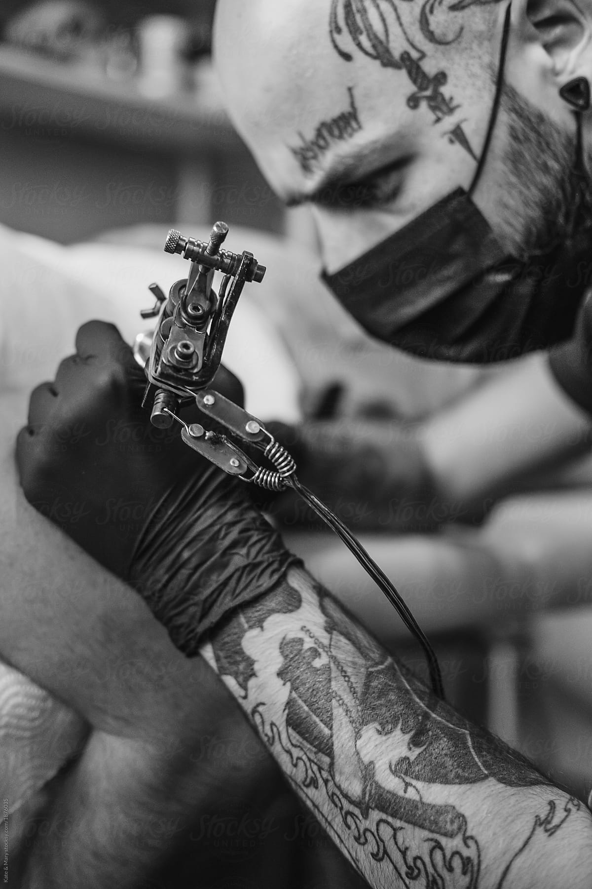 Tattoo artist drawing on client's skin