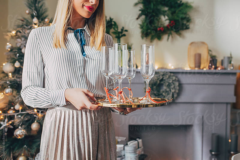 Woman Holding Tray With Wine Glasses For Christmas Dinner