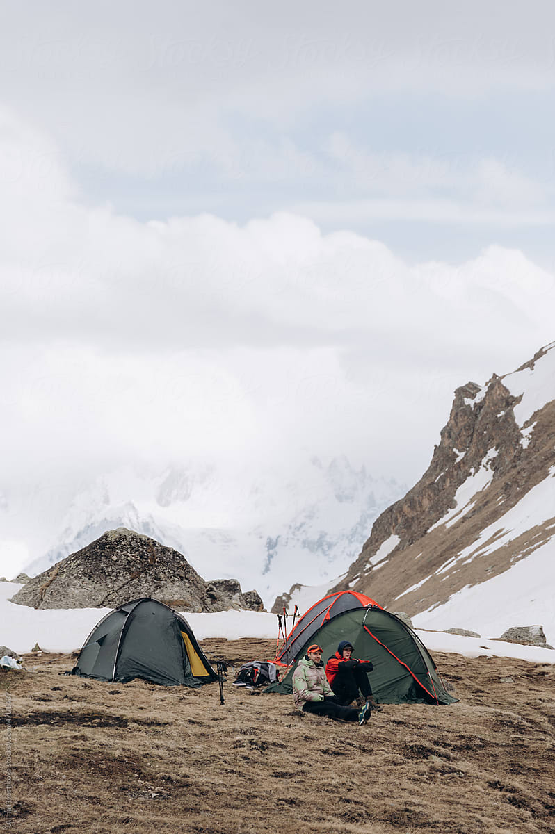 Campers resting near snowy mountains