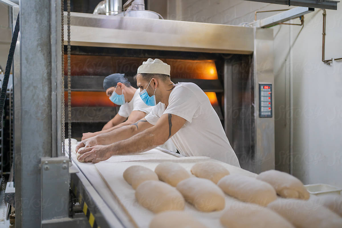 Colleagues Preparing Bread Before Putting On The Oven.