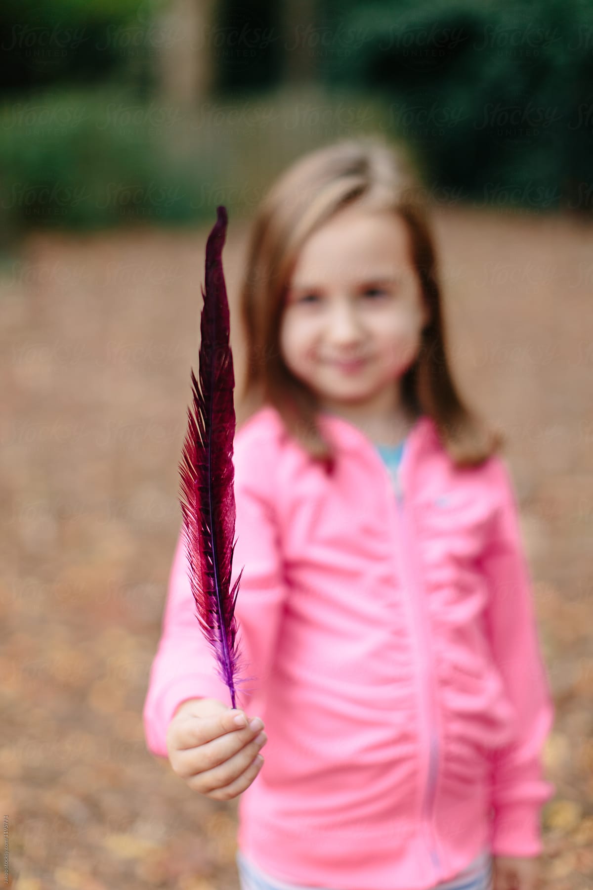 Cute Young Girl Out Exploring With A Feather In Her Hand By Stocksy 4440
