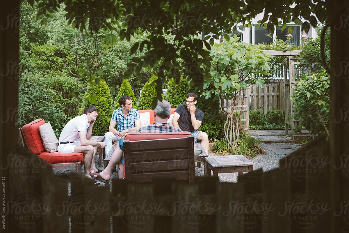 Group of Gay Men Friends at Spring Drinks Party in a Home Backyard Garden