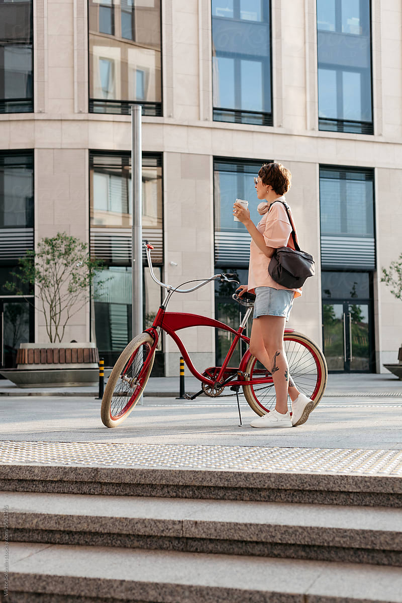Stylish woman with bicycle on street