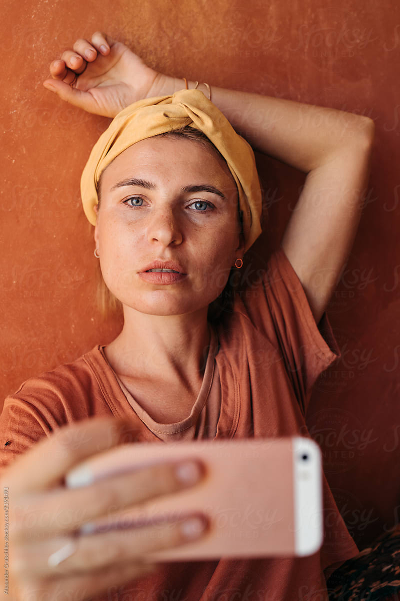 Woman Taking Selfie In Front A Orange Wall