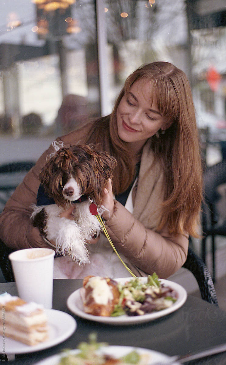 young woman seating in a caffe with funny dog