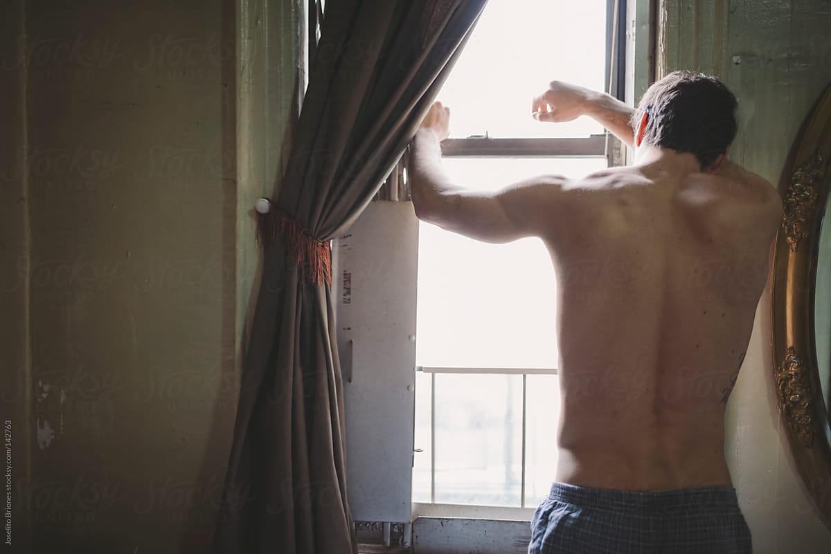 Shirtless Man in Boxer Shorts Looking Out the Window