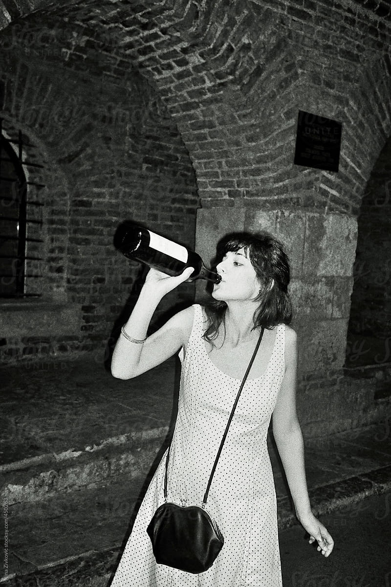 A young girl drinking wine.