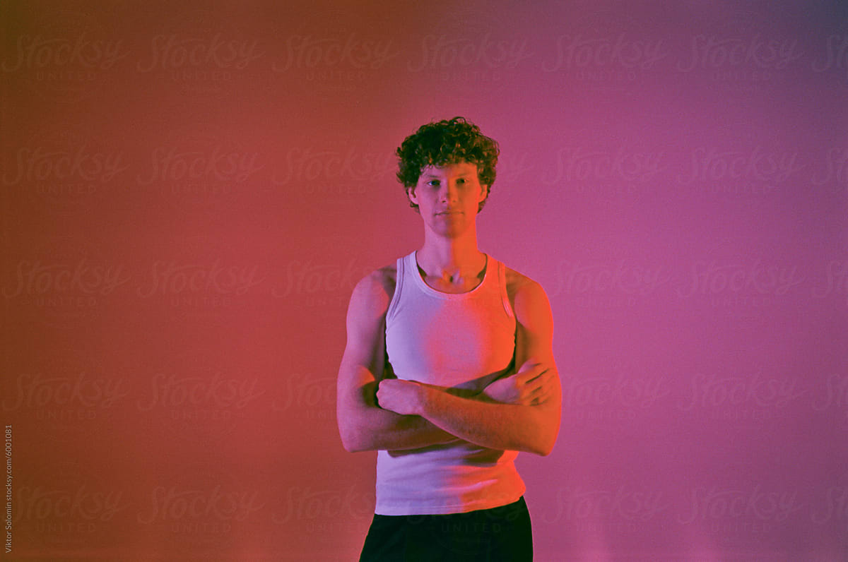 Confident sportive man with crossed arms in studio