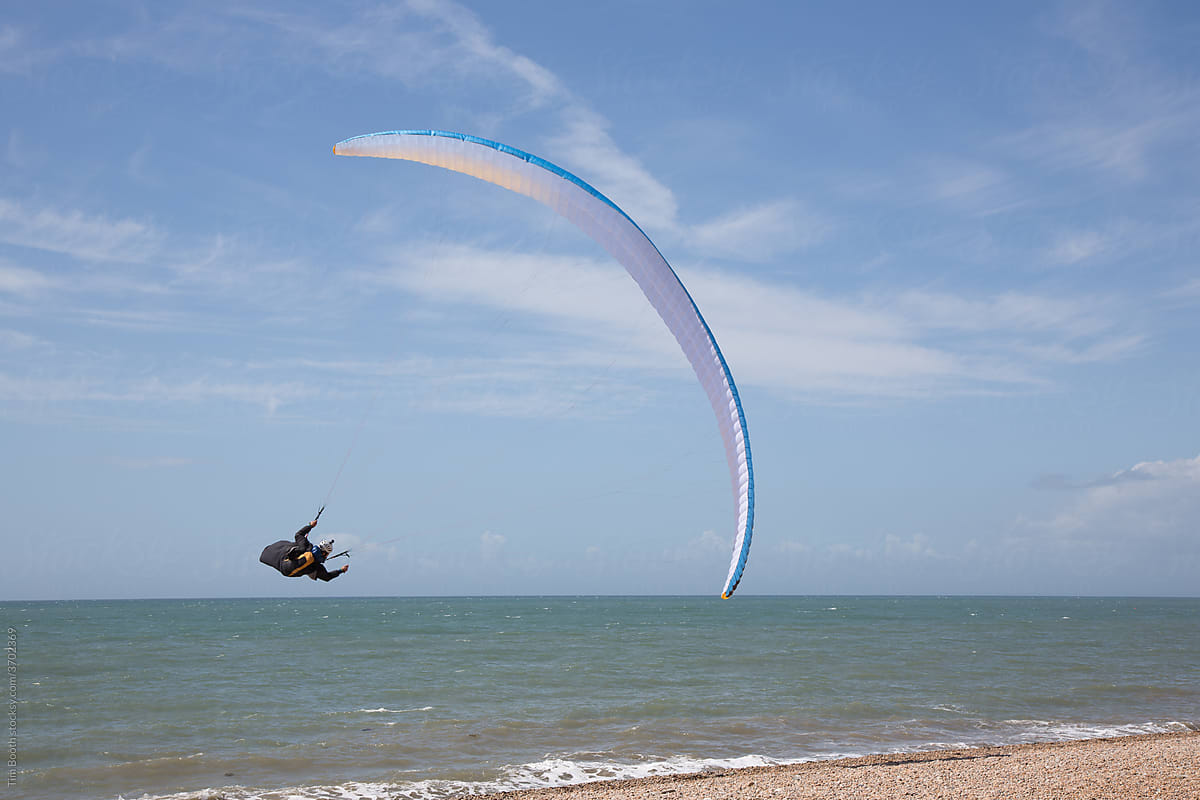 Paraglider flying above the beach