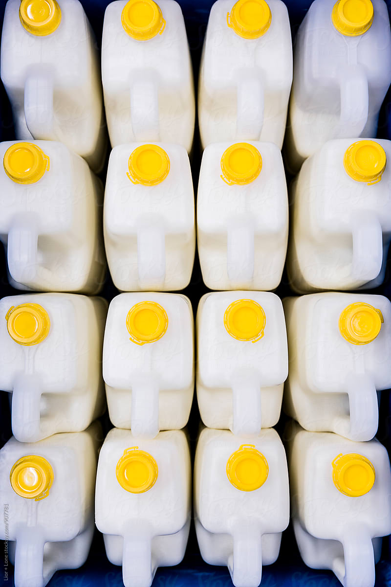 Sixteen large industrial bottles of cream shot from above