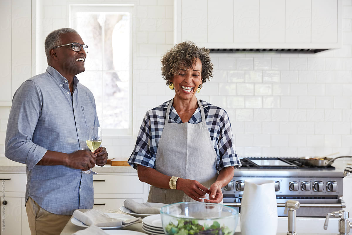 Senior Black couple preparing a meal together in kitchen