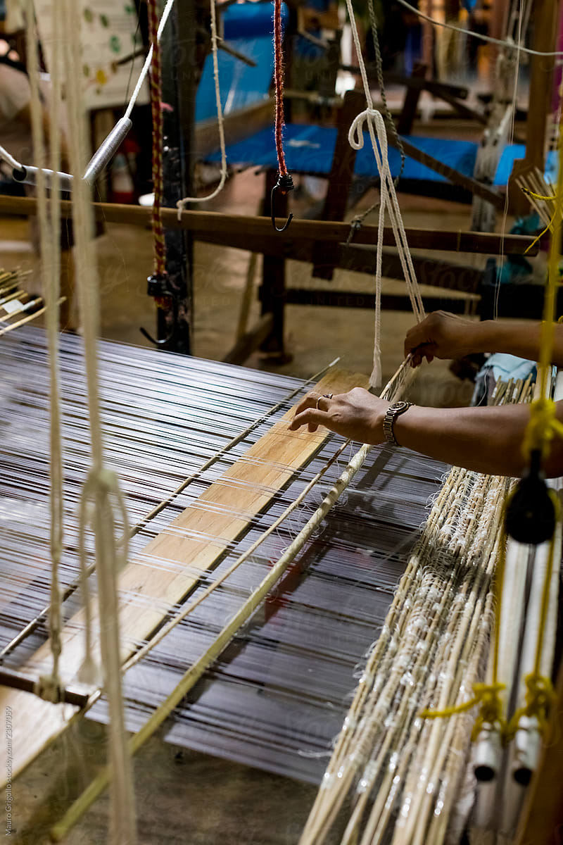 A woman using the loom to make silk fiber
