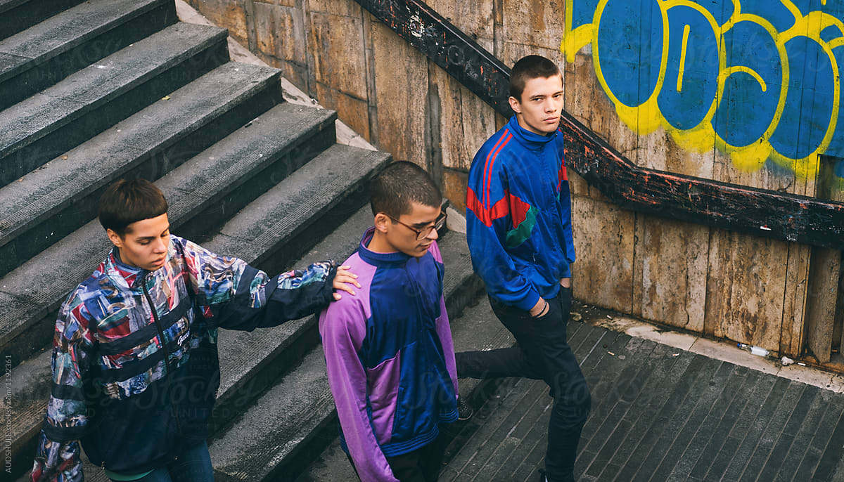 Young adolescents in colorful track suits from 90\'s in east Europe projects.