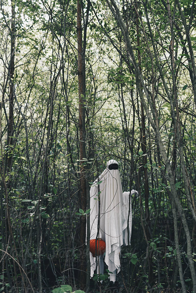 Ghost with pumpkin in forest