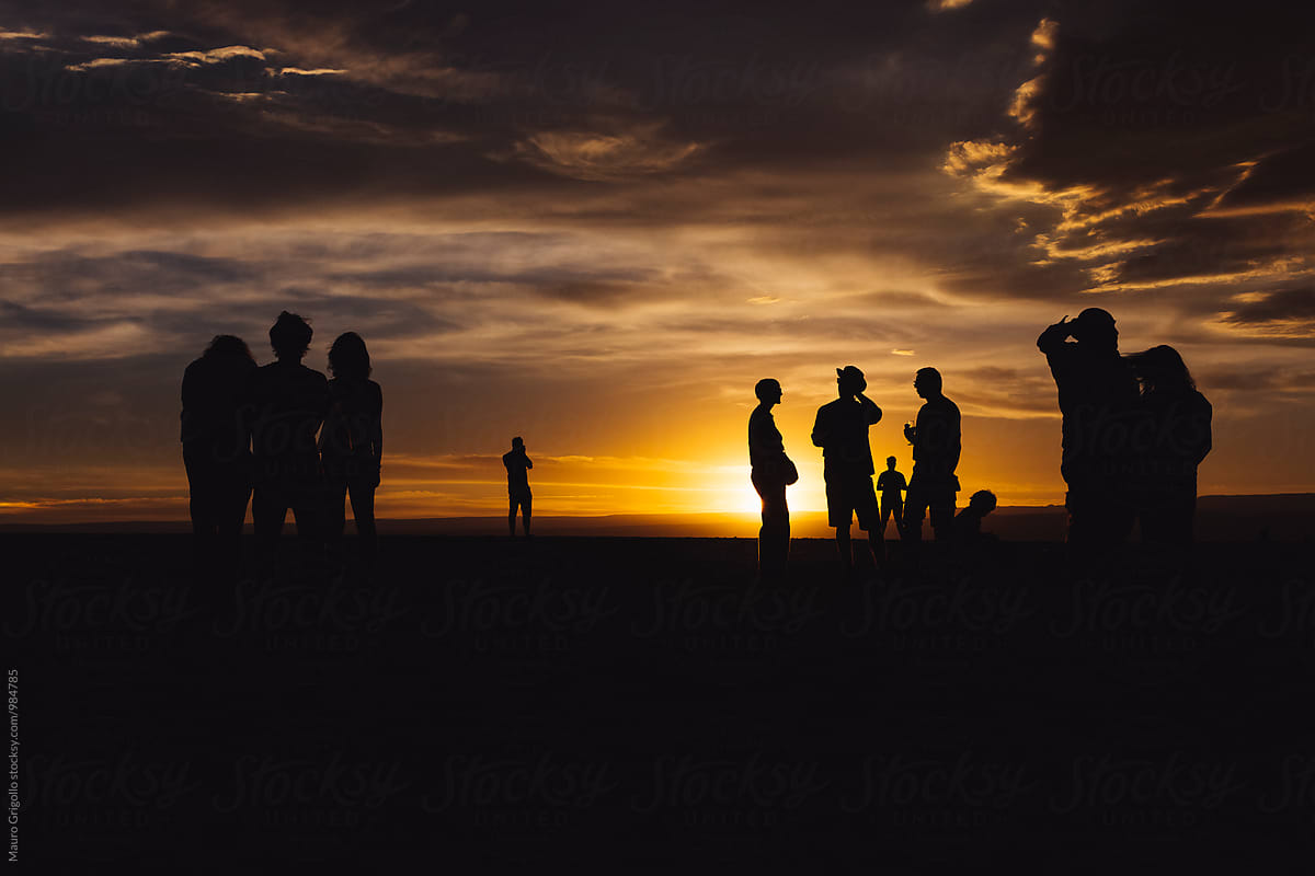 Silhouette of a group of people looking at sunset