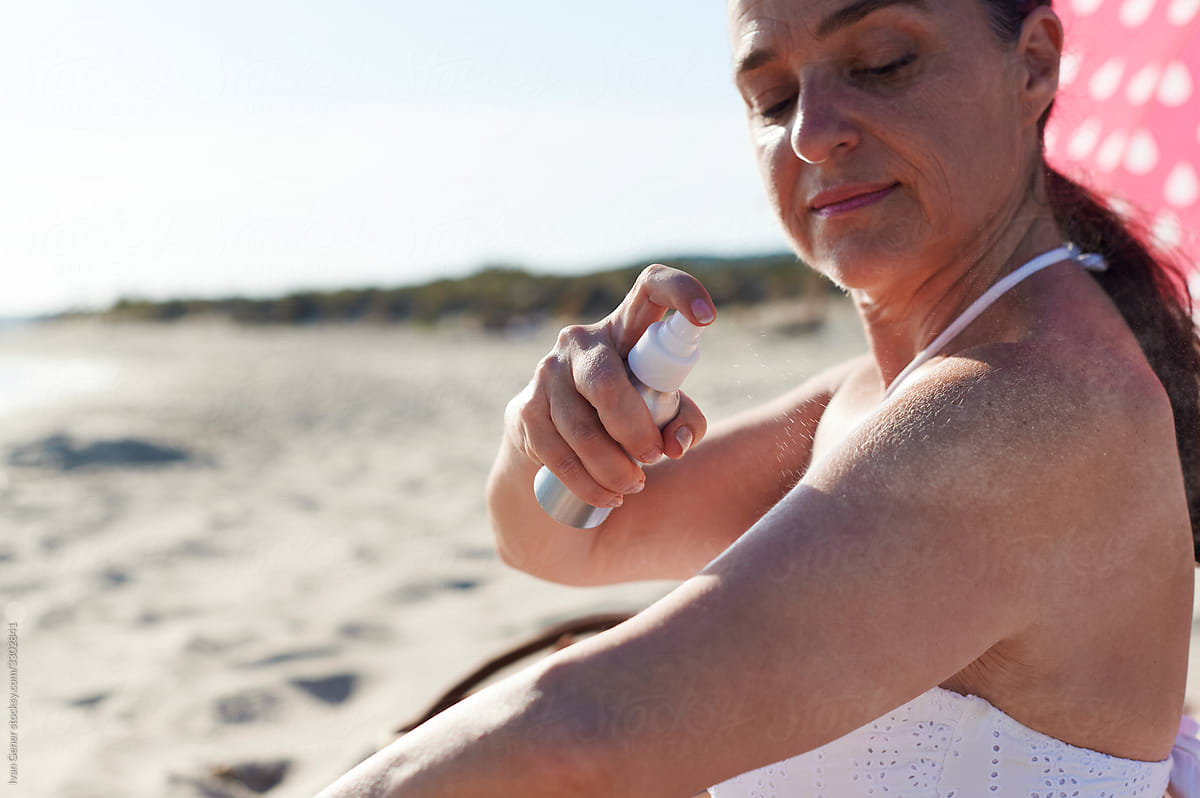 Woman applying sunblock on a beach