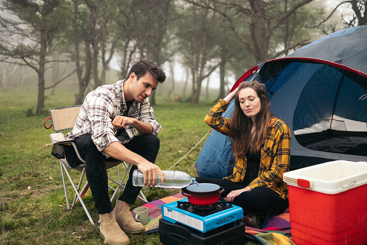 Couple camping and preparing food with camping gas