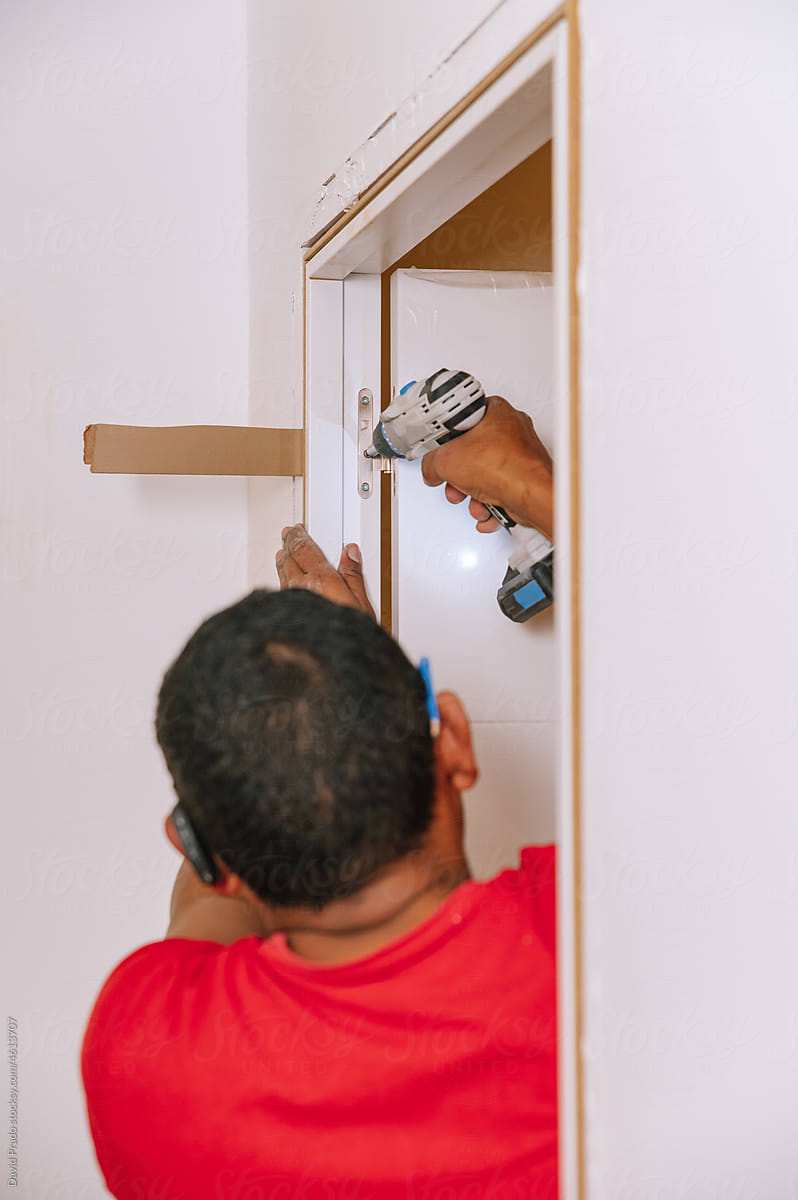 Handyman installing door in apartment