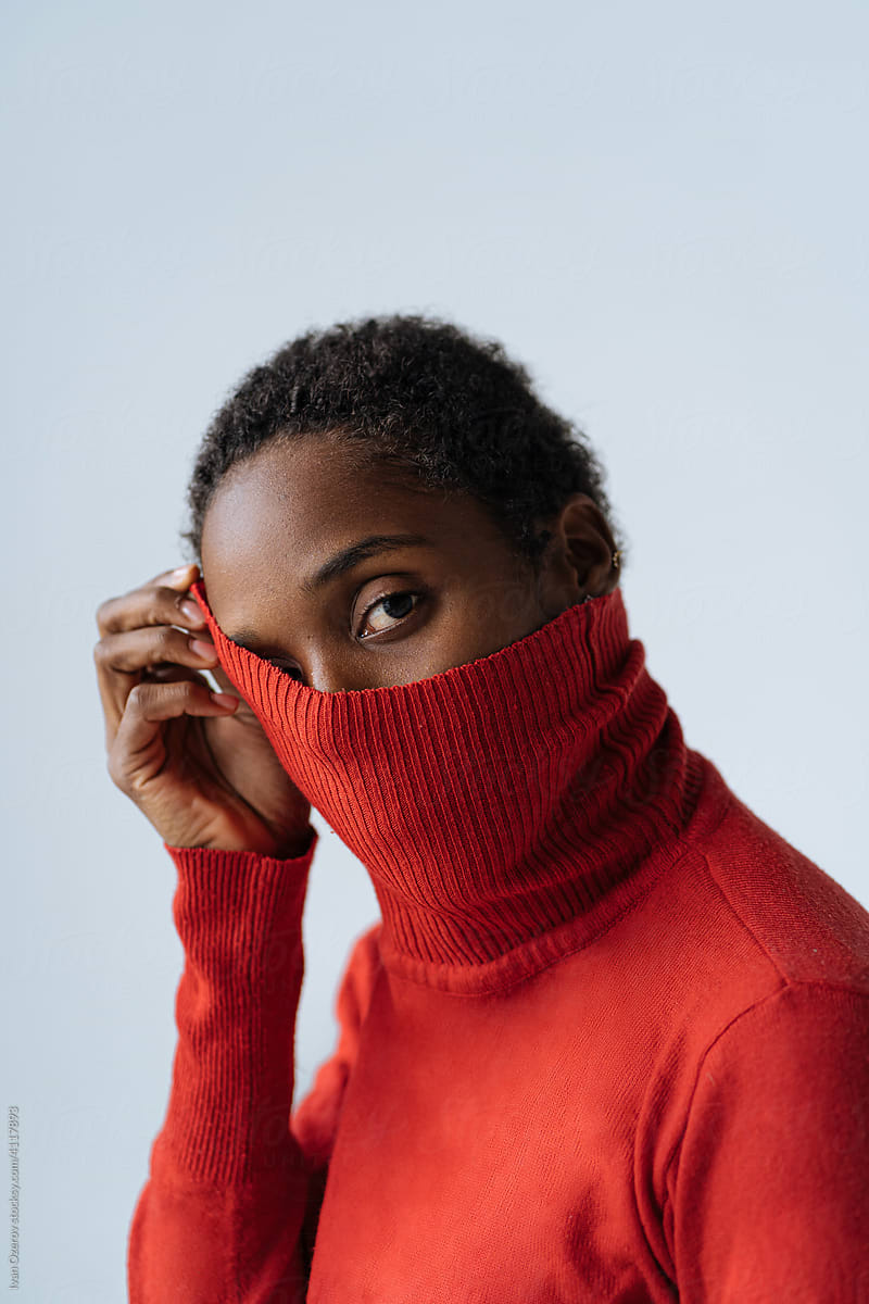 Black woman covering face with turtleneck