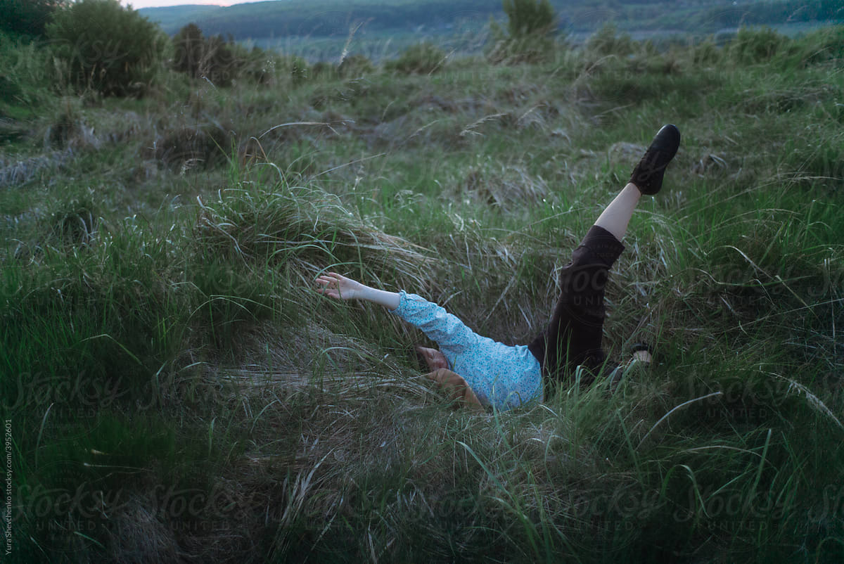 woman contemporary dancer dancing improvisation on a meadow at dawn