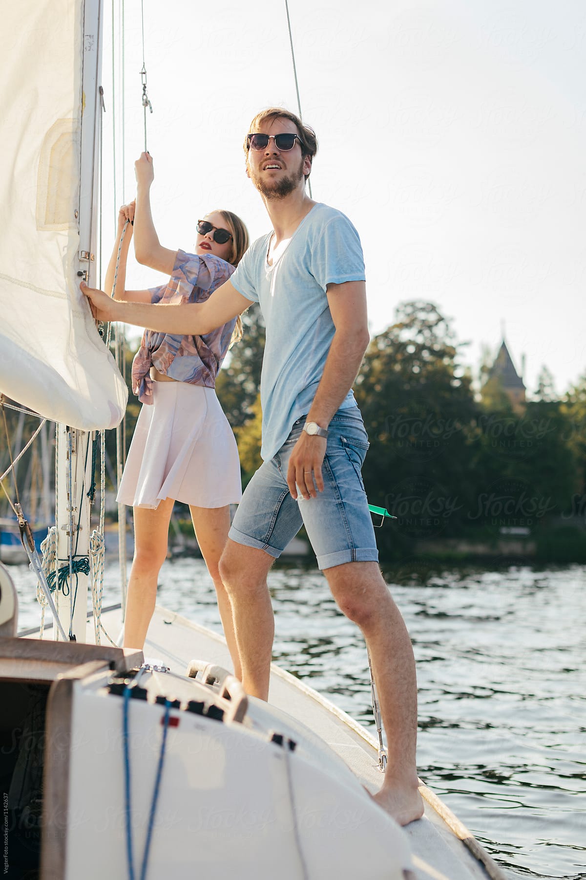Man and woman hoisting sail