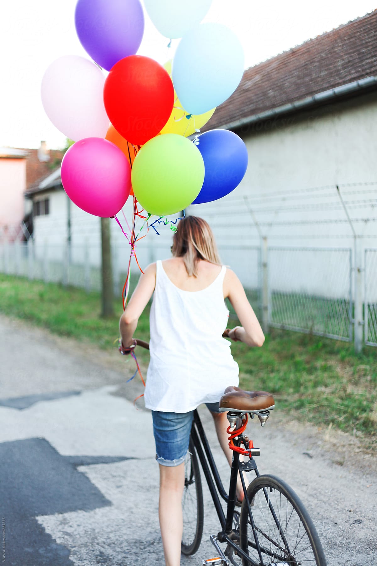 Woman riding a bicycle with colorful ballons