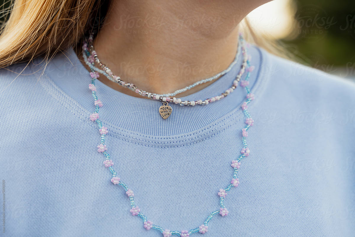 Close-up of handmade beads necklace on teenager girl outdoors.